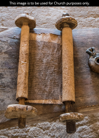 A scroll of worn parchment lying on a crude table.