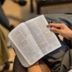 A young man reading the Book of Mormon during a youth study group.
