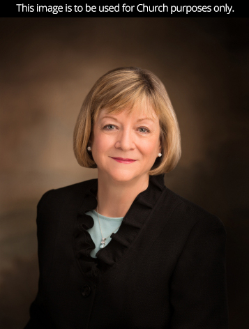 A portrait of Sister Bonnie L. Oscarson, who is wearing a black jacket, in front of a brown background.