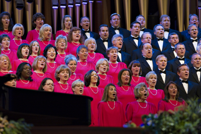 The Mormon Tabernacle Choir, with the women in red dresses and the men in black suits, singing in the Pioneer Day Commemoration Concert in July 2008.