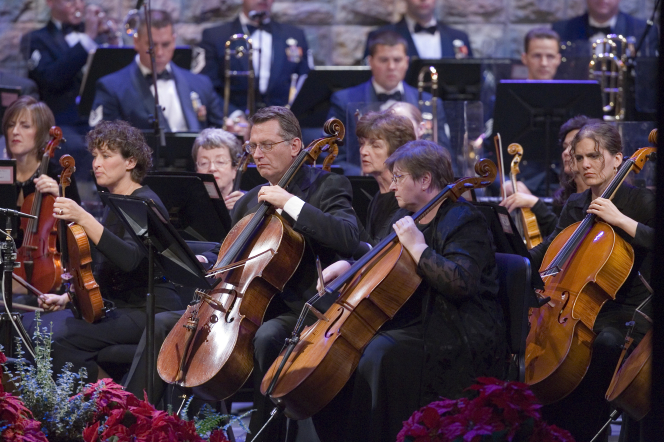 The orchestra playing in the Conference Center, with the women dressed in black and the men in white shirts and suits.