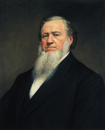 A painted portrait by John Willard Clawson of Brigham Young with a long white beard, wearing a black suit.