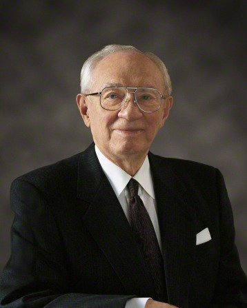 A portrait of President Gordon B. Hinckley smiling in a black suit, white shirt, and glasses.
