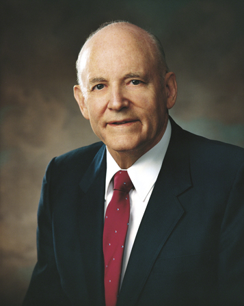 A portrait of President Howard W. Hunter in a dark blue suit, white shirt, and red tie.