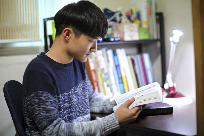 A young man studying his scriptures.
