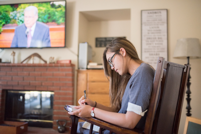 A young woman takes notes.