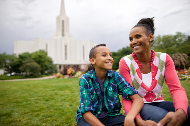 A mother and her son sitting in front of a temple.