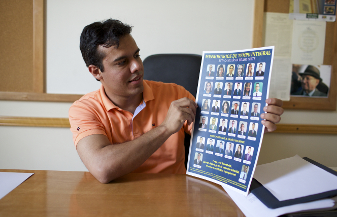 A man holding up chart of missionaries.
