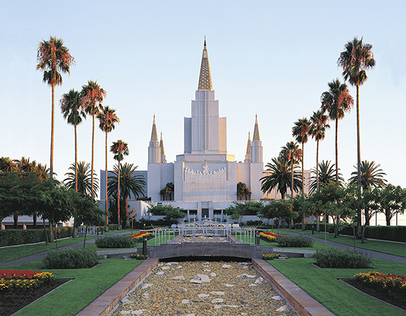 The Oakland California Temple seen from the front, with a large bridged water feature leading up to it.