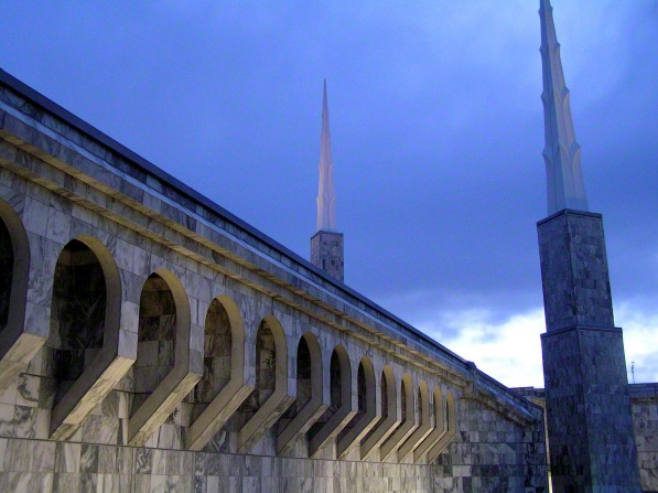 The arches on the side of the Boise Idaho Temple at dusk, with the temple’s spires in the background.