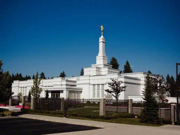 The front of the Spokane Washington Temple, including a view of the entrance, the fence, and trees on the grounds.